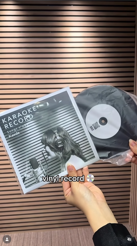 Hands holding a fresh vinyl record and its printed sleeve